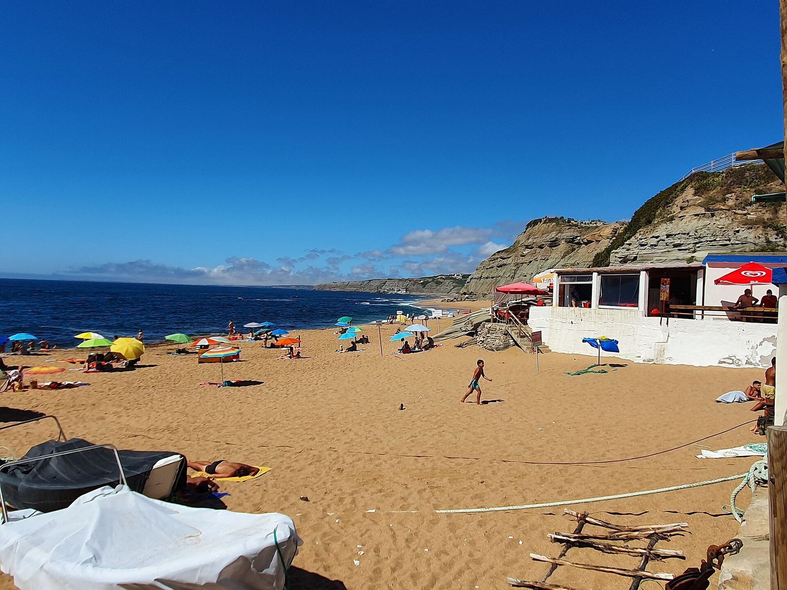 Praia de Porto Dinheiro with fishing boats and beach umbrellas