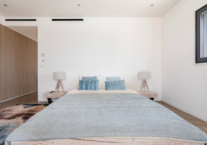 The Driftwood Room: Bett mit blauen Kissen und Nachttischlampen