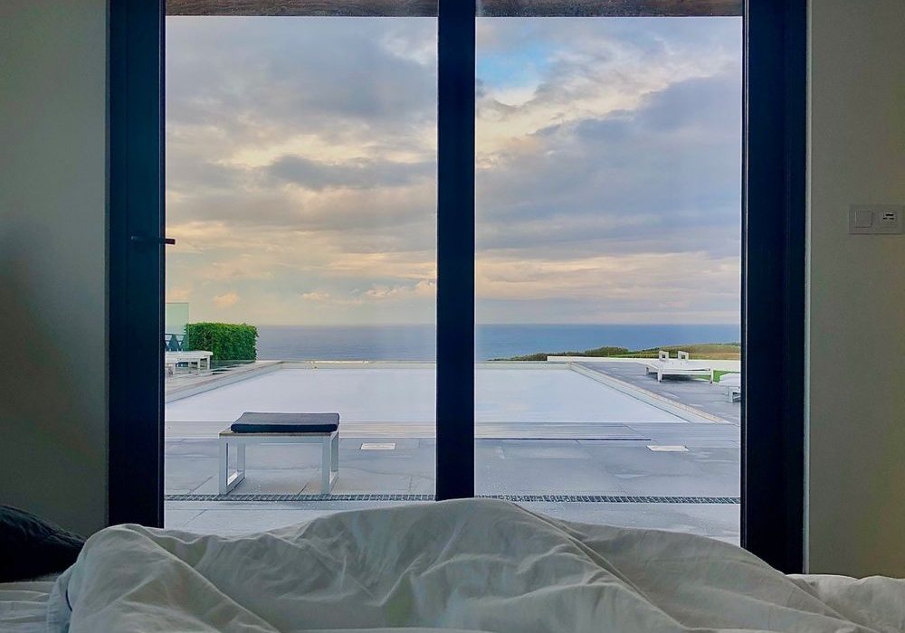 The Driftwood Room: Aufwachen mit Blick durch die Glastüren auf Pool und Atlantik
