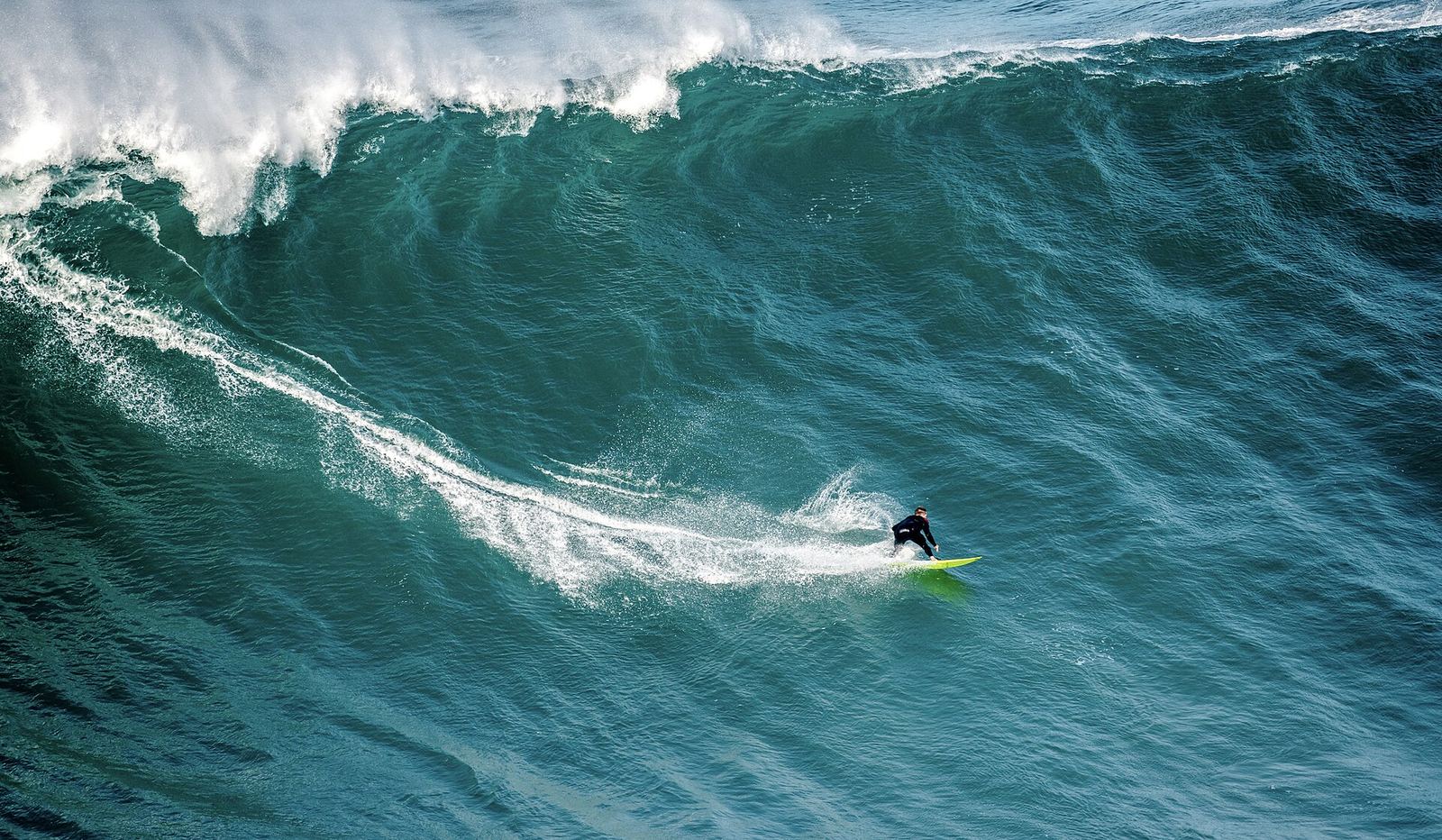 A surfer riding a giant wave in Nazaré