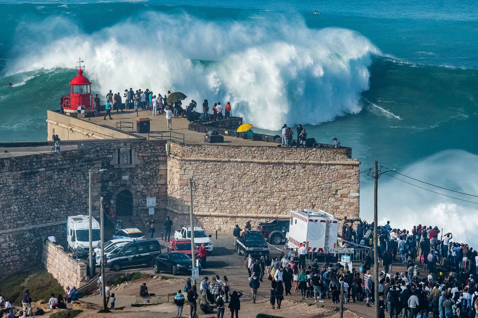 Crowds at the Nazaré lighthouse watching a huge wave